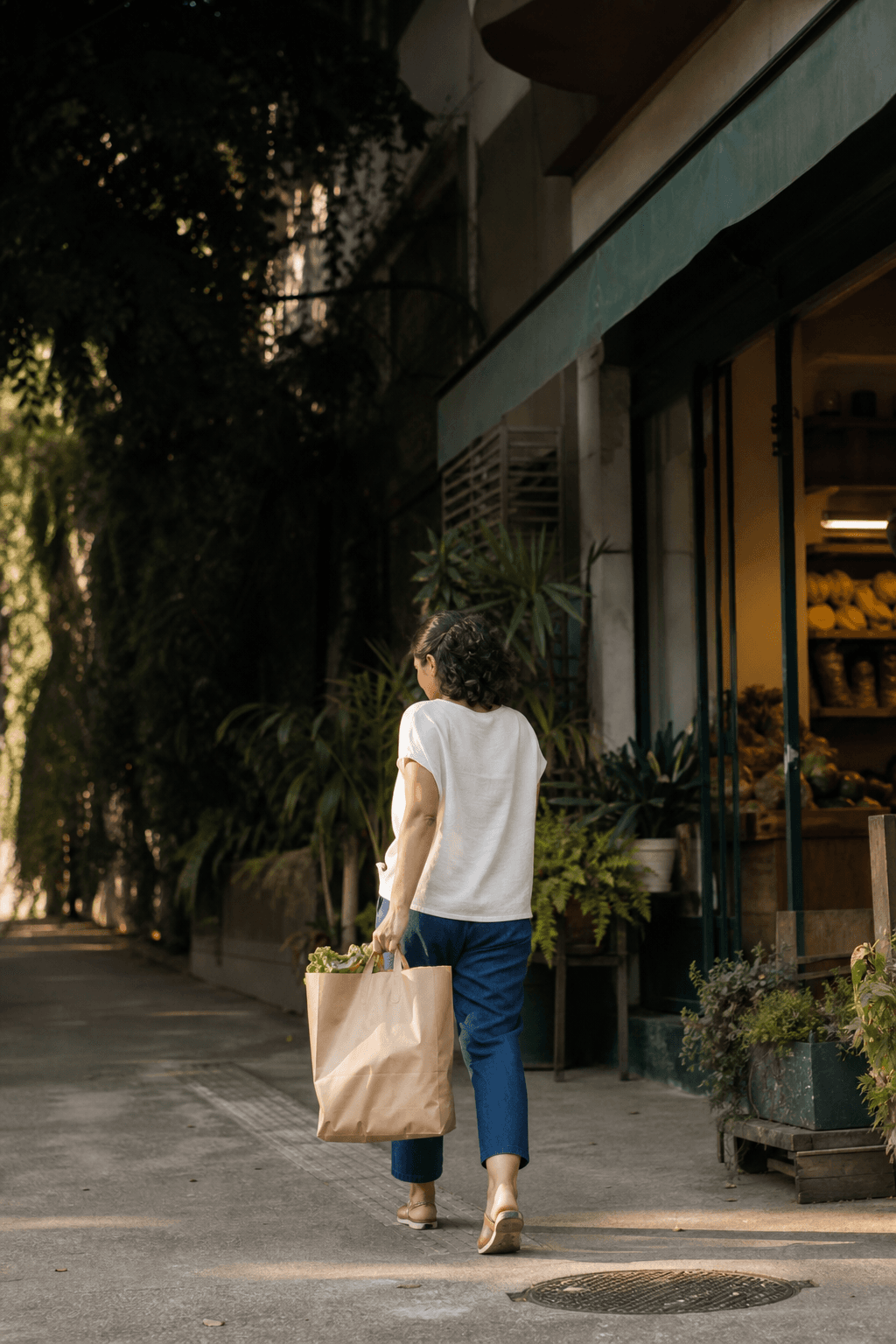 Pessoa saindo de um comércio do bairro com a sacola de compras